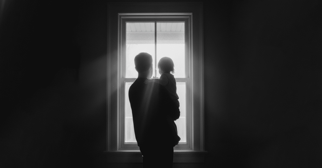 homem-segurando-crianca-nos-bracos-olhando-pela-janela-para-luz-da-manha-1024x536 A Responsabilidade Paterna que Falta a Tantos Homens